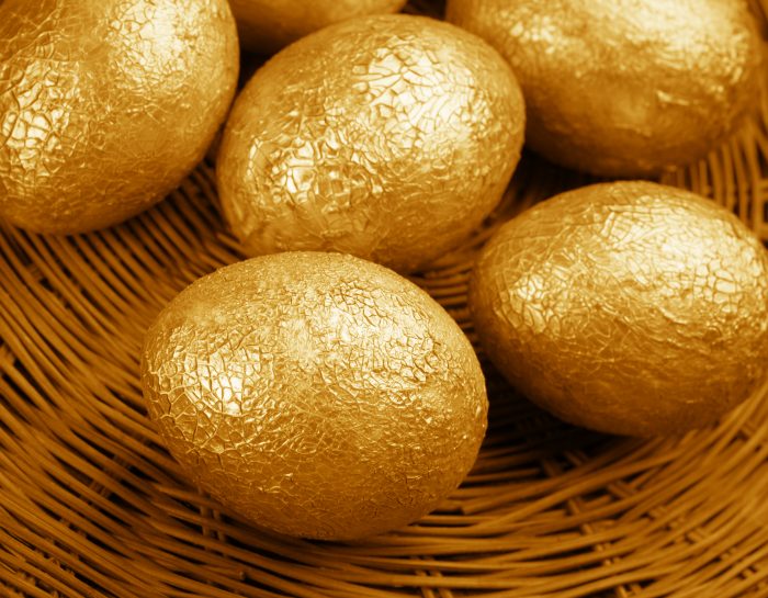 Group of crackle golden Easter eggs in wicker basket.